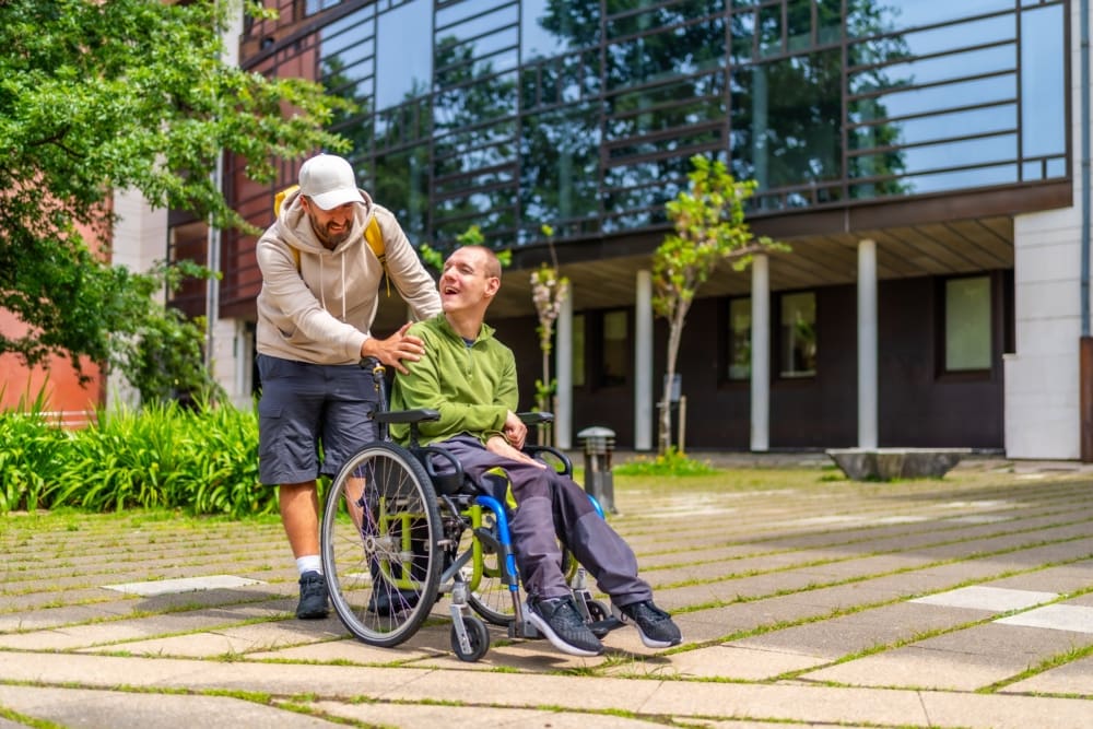 Man pushing another man in a wheelchair